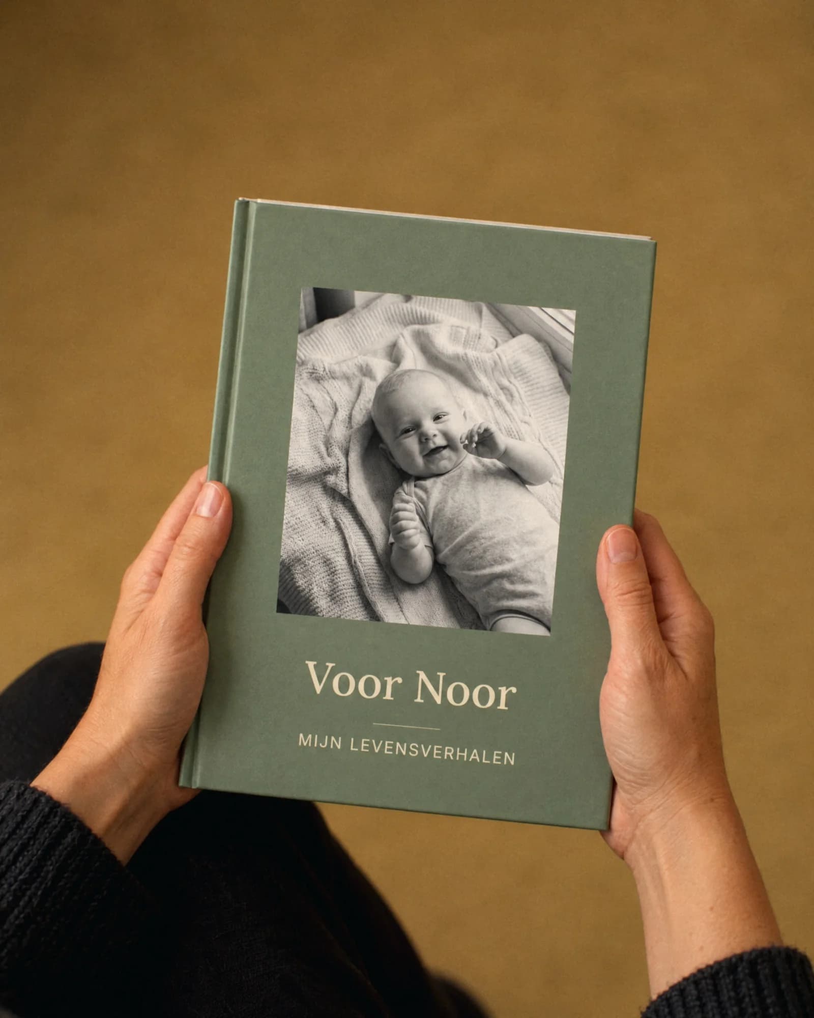 Des mains tiennent le livre de bébé Voor Noor.