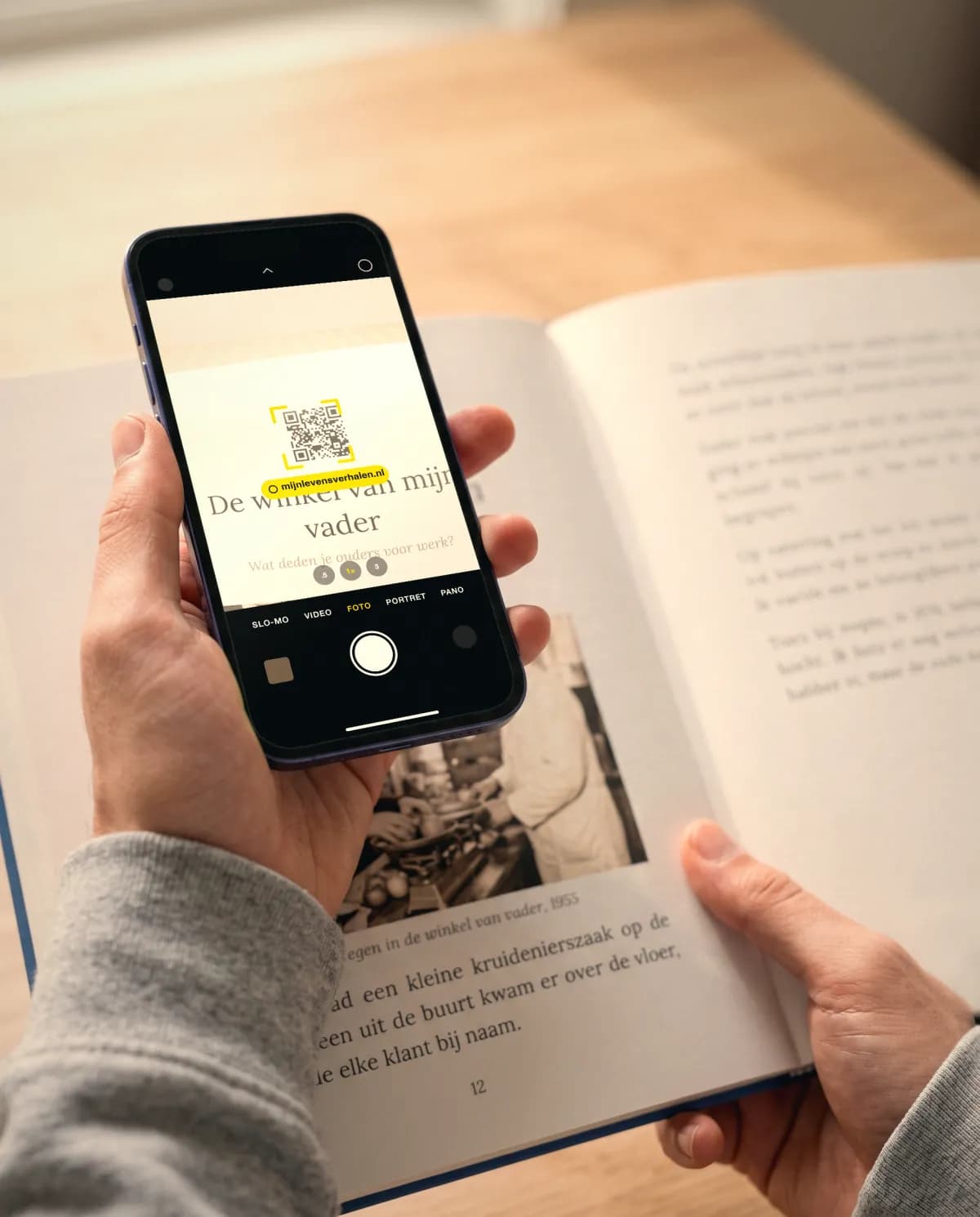 Quelqu'un scanne un code QR dans un livre Nos Histoires.